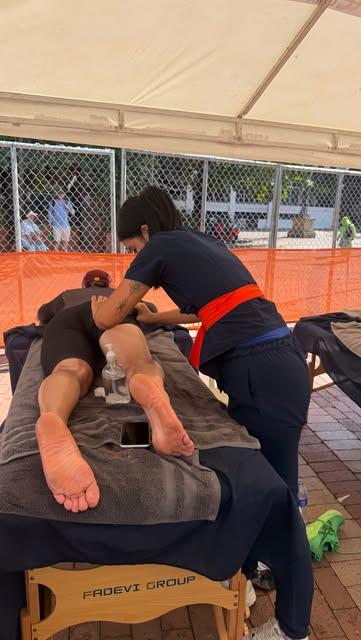 Terapeuta de Hom Spa dando masaje a un atleta en una carpa